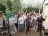 People standing together in a garden waving their hands in the air.