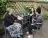 3 women seated at an outdoor table chatting and smiling.