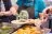 A622277_Food at FoodCycle Peterborough_Peterborough Think Communities A person with an apron branded with FoodCycle's logo putting some food on a plate.