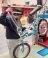 A person fixing a bike in an indoor workshop.