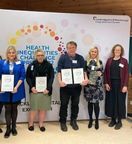 Finalists of the Health Inequalities Challenge Prize 2022 standing in front of a banner with the prize's logo.