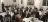 People seated at tables at a black tie event.