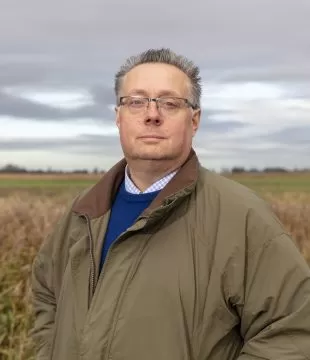 A headshot of Michael Sly, Vice President of the Foundation, standing outside in a field.