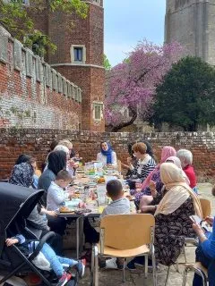 People sitting outside at a table eating a picnic.
