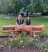 Two women stand by a woodencommunity sign that says Parson's Drove
