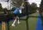 Cricketer swings bat in a netted cricket area